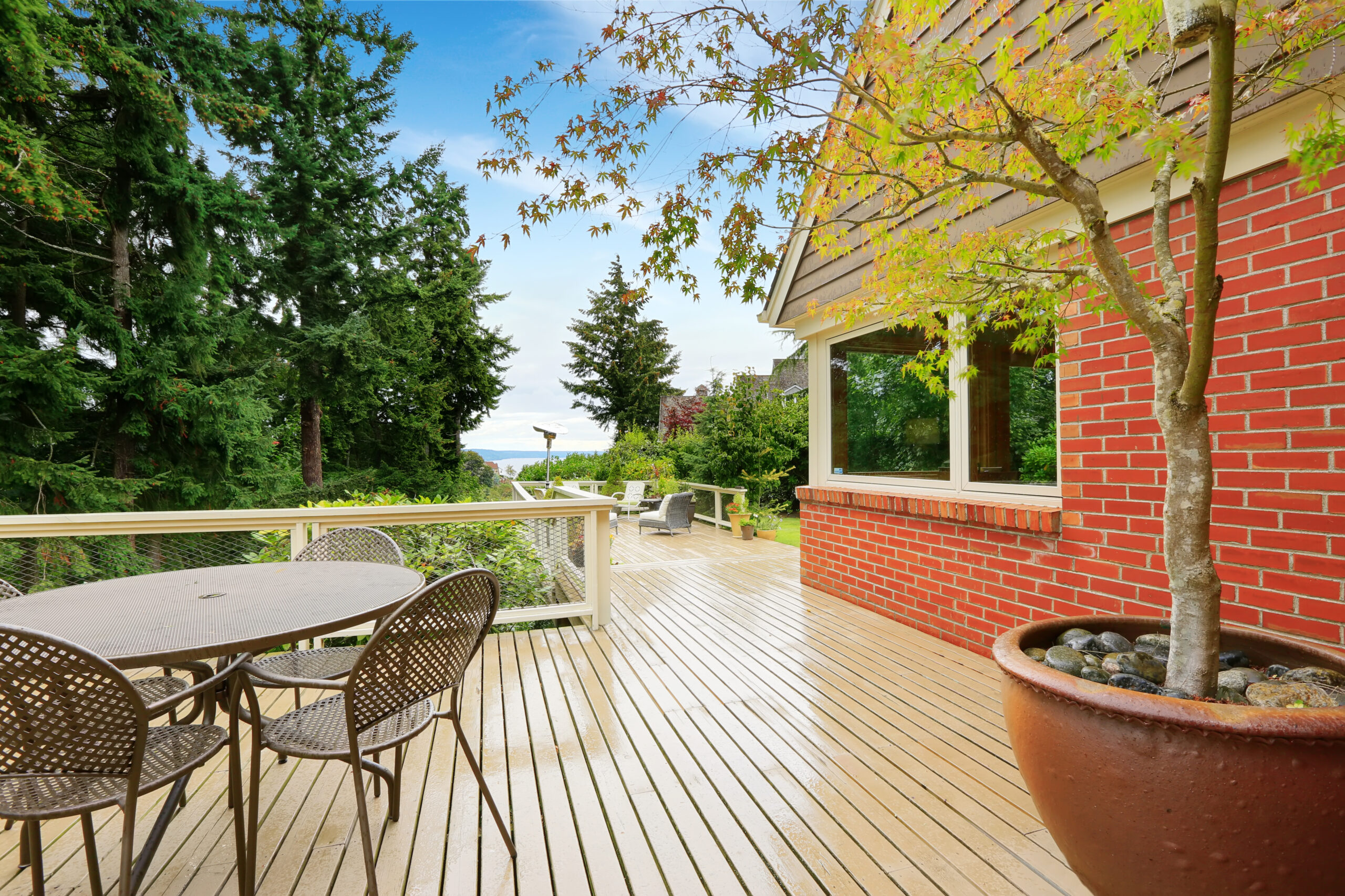 Patio and sitting area on spacious walkout deck. Brick house exterior